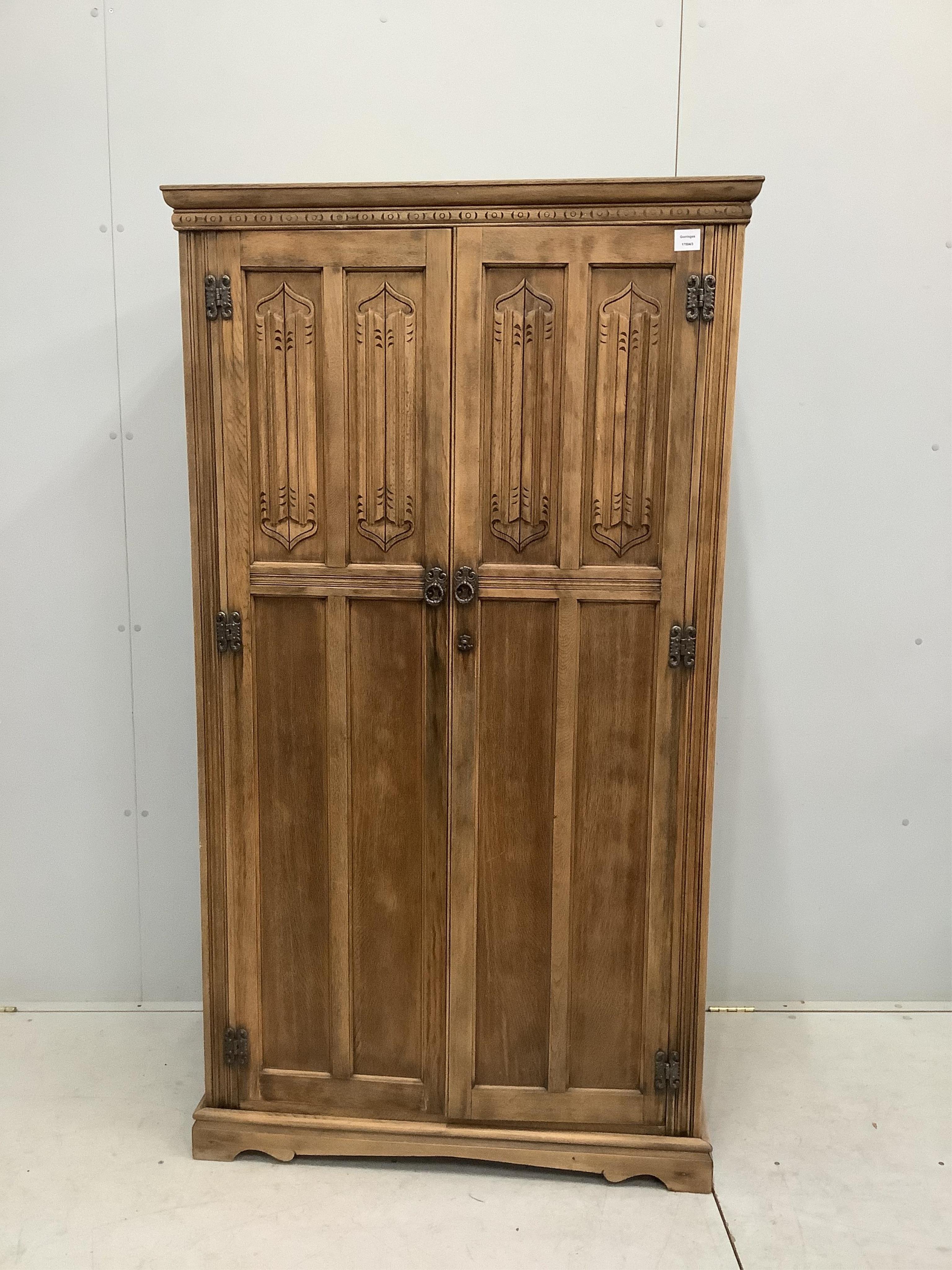 An early 20th century oak linenfold moulded oak compactum wardrobe, width 96cm, depth 53cm, height 174cm. Condition - fair